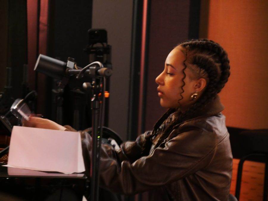 Nandi singing from her lyric sheet