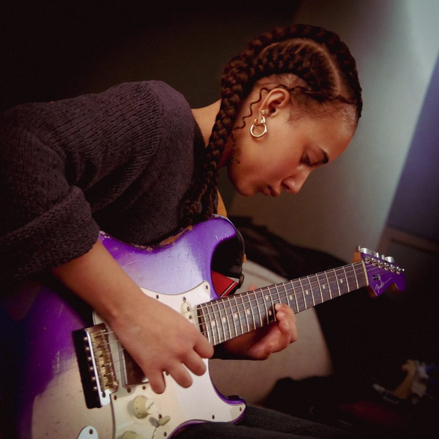 Nandi playing a purple guitar